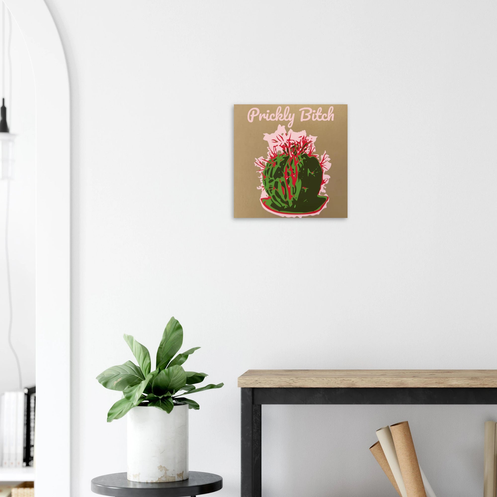 Prickly Bitch cactus crown print on textured dark wall above white sofa